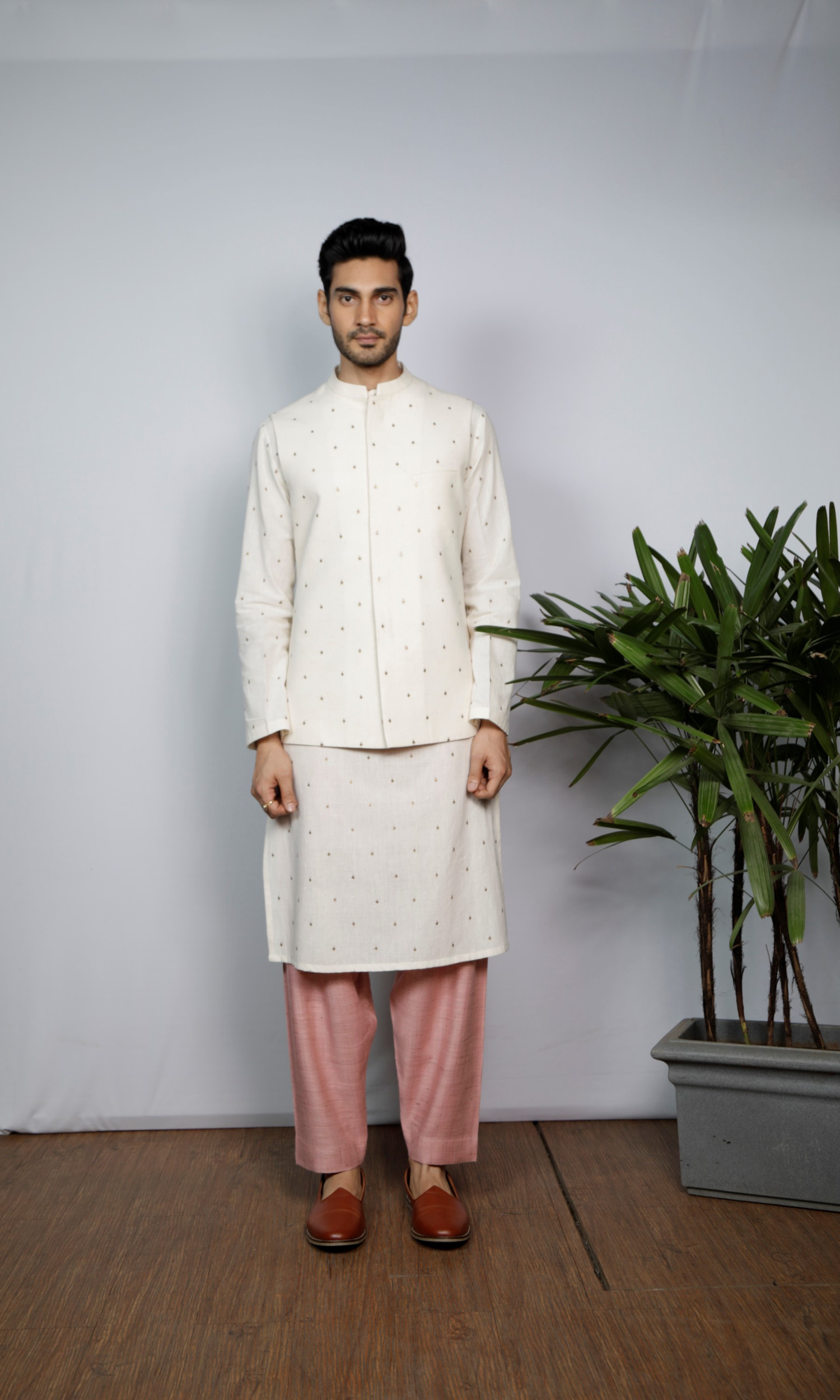 White bandi with emb motif paired with emb kurta and salmon pink indie pants