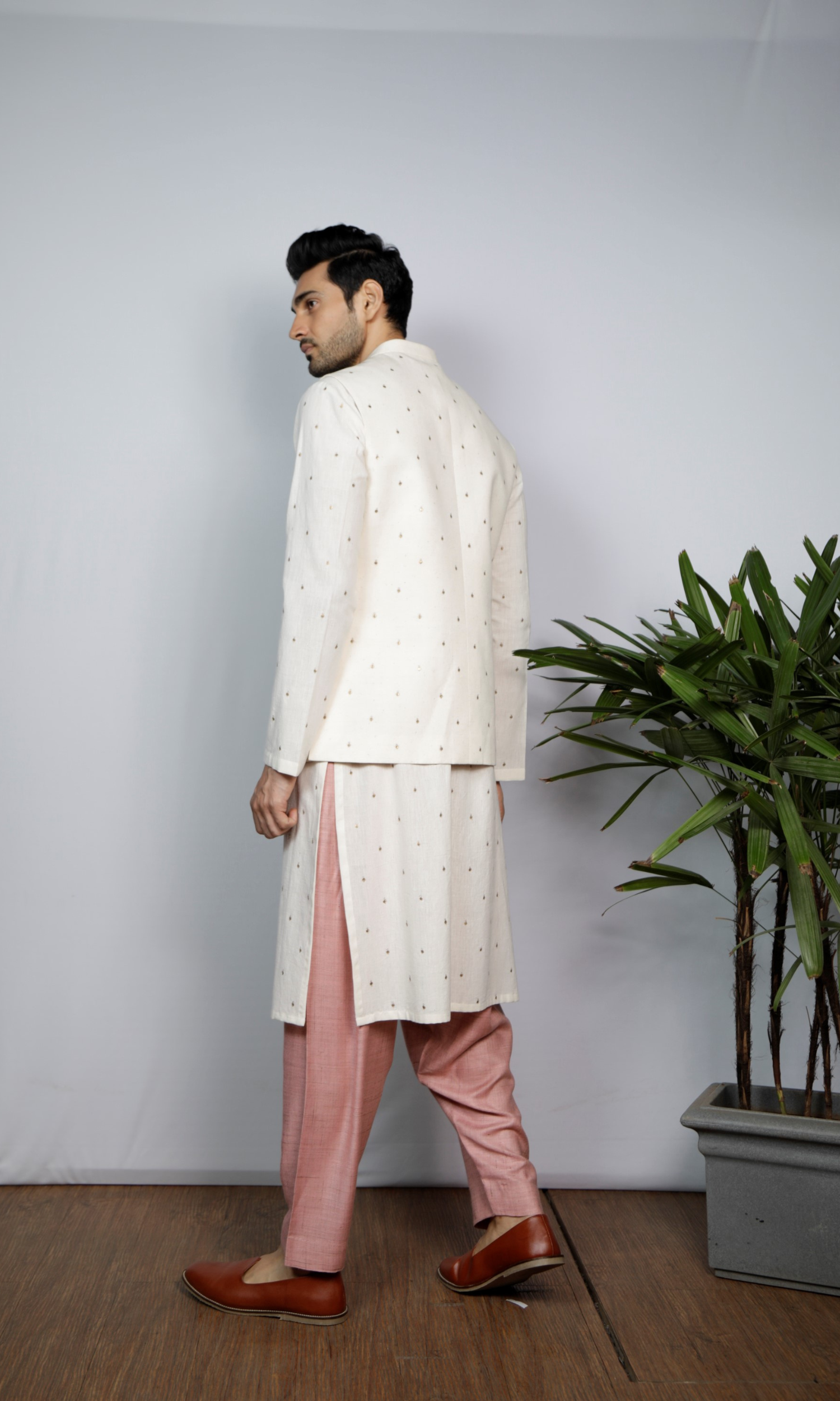 White bandi with emb motif paired with emb kurta and salmon pink indie pants