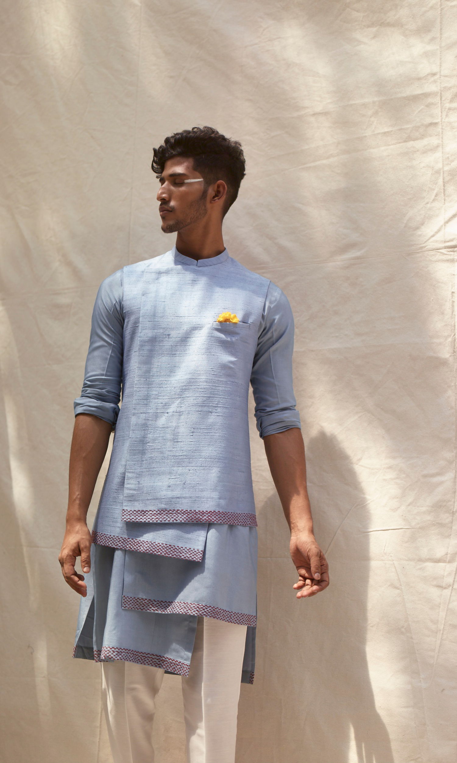 Powder blue asymmetric bandi paired with asymmetric kurta and pants