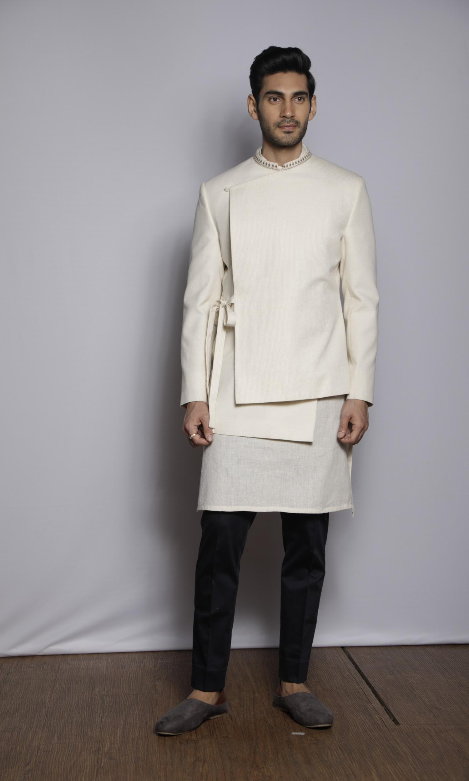 Off white asymmetrical self threading bandhgala with tie up and collar emb detail paired with a kurta and fitted pants