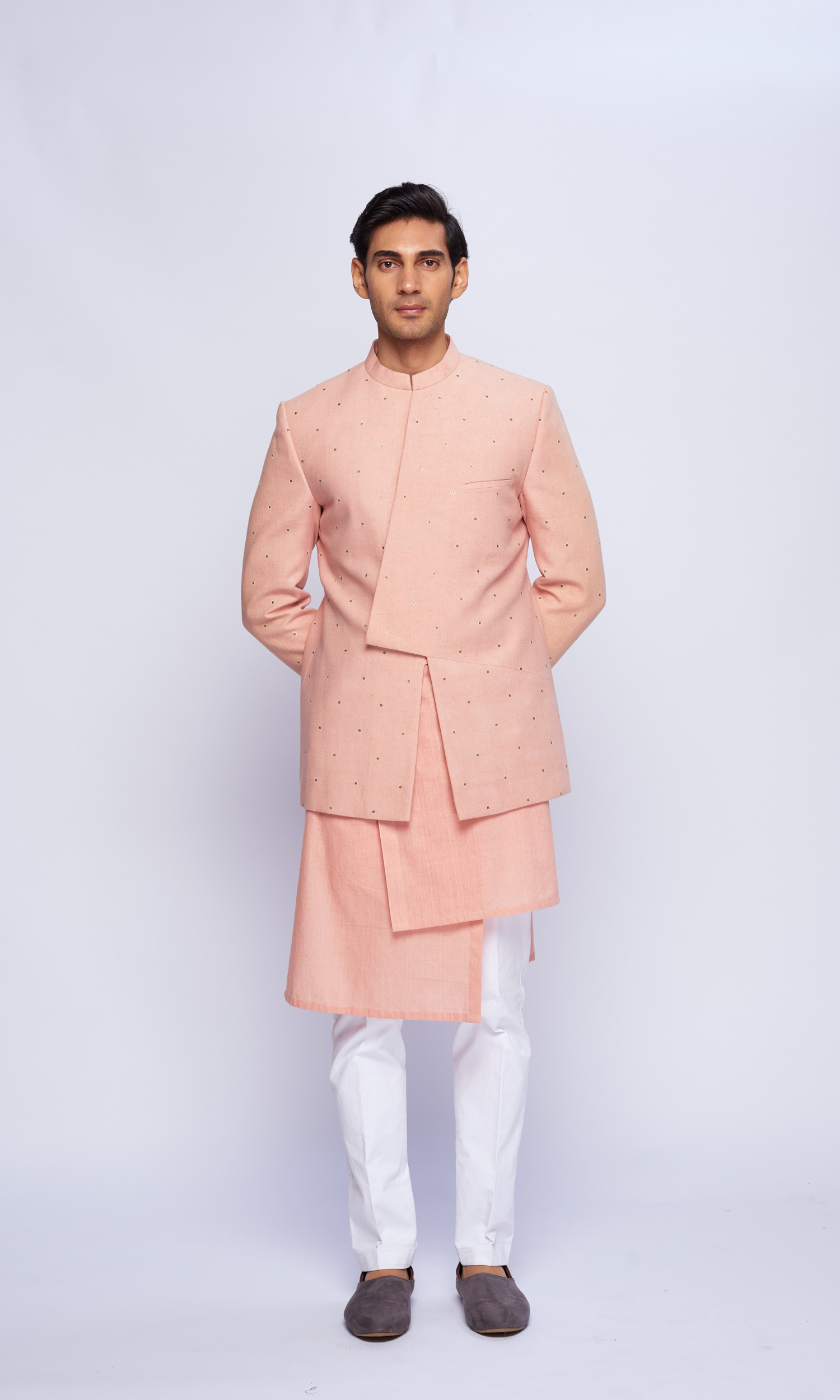 Dusky pink asymmetric yoke all over emb bandhgala paired with tonal asymmetrical kurta and fitted pants