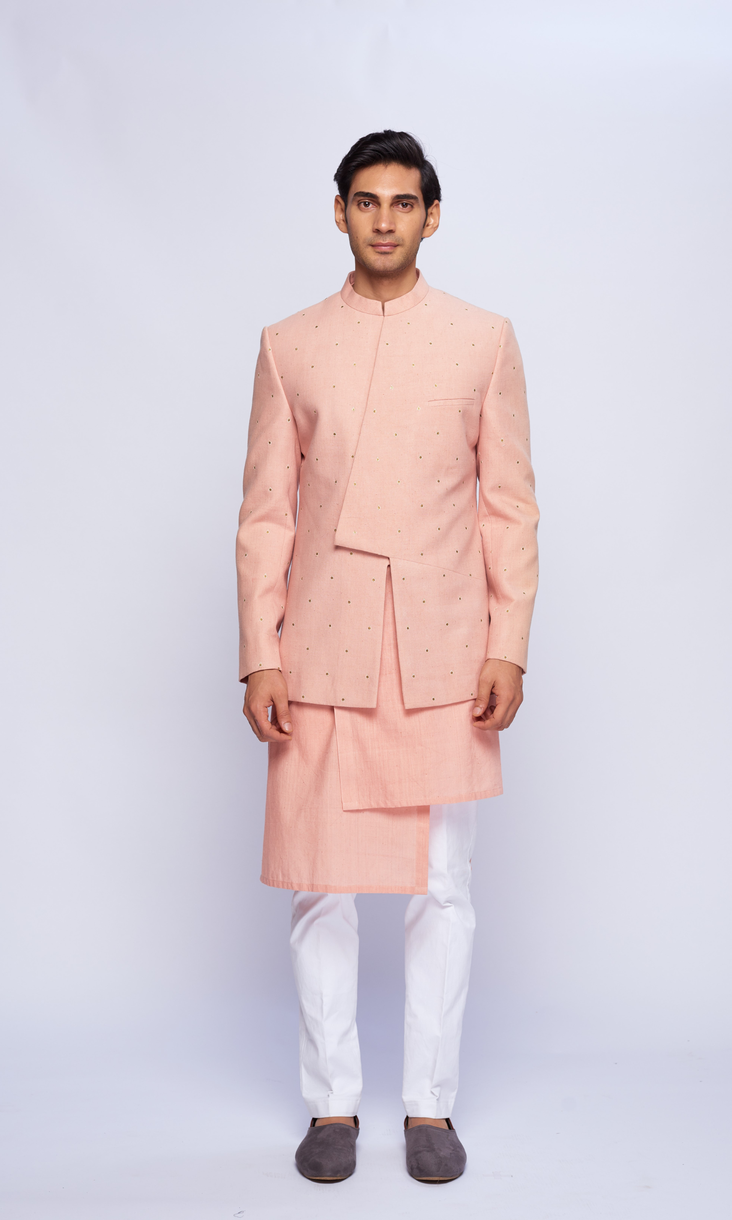 Dusky pink asymmetric yoke all over emb bandhgala paired with tonal asymmetrical kurta and fitted pants