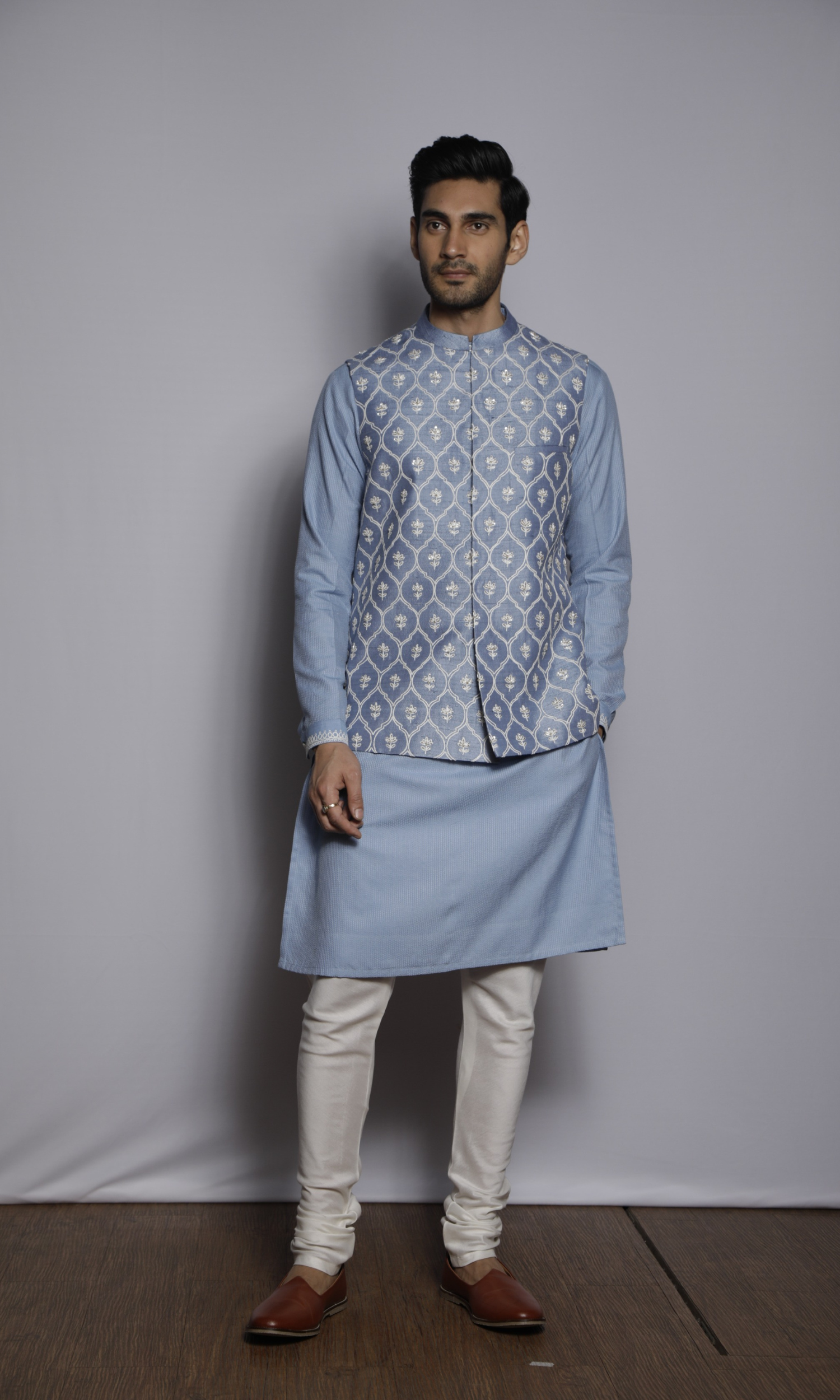 Off white asymmetrical bandi paired with off white asymmetrical kurta and dark grey fitted pants
