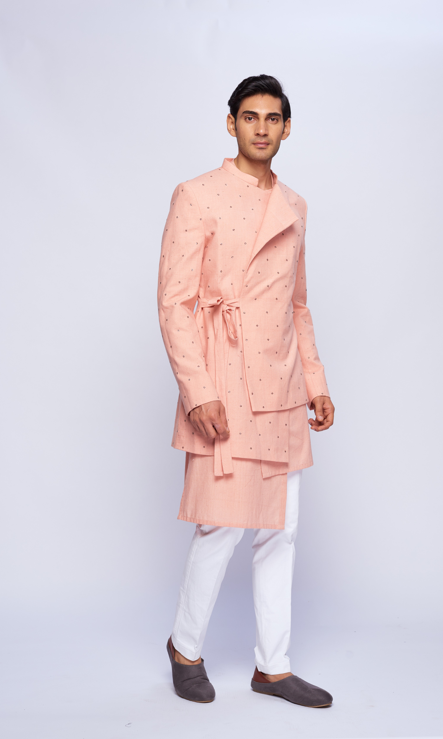Dusky pink asymmetric all over motifs bandhgala  paired with tonal asymmetric kurta and fitted pants