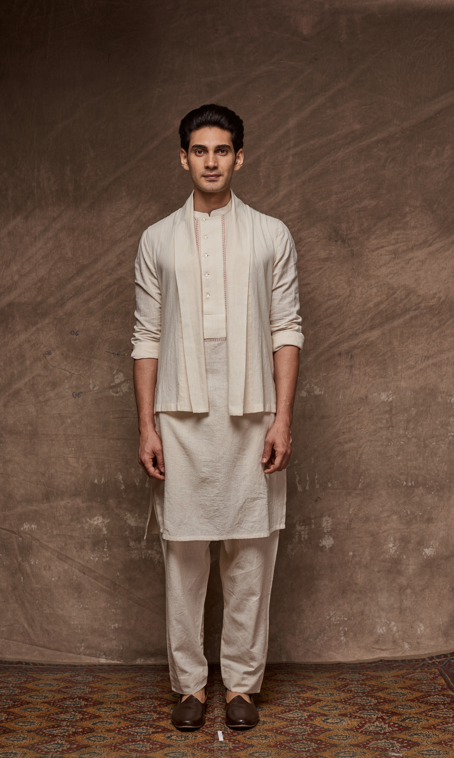 Off white cape paired with tonal kurta and indie pants