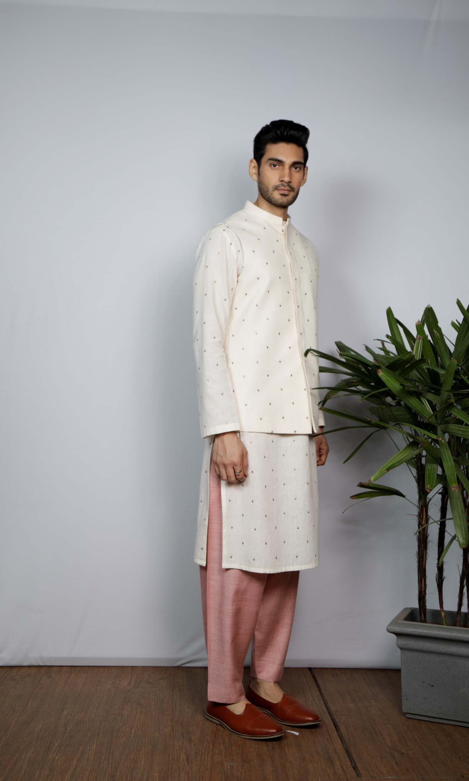 White bandi with emb motif paired with emb kurta and salmon pink indie pants