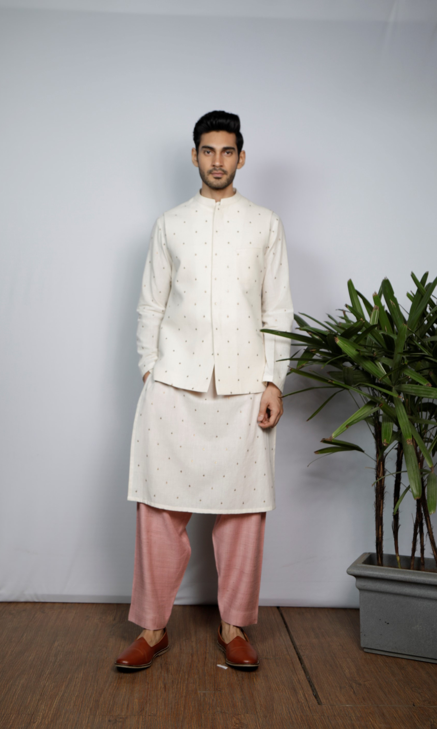 White bandi with emb motif paired with emb kurta and salmon pink indie pants