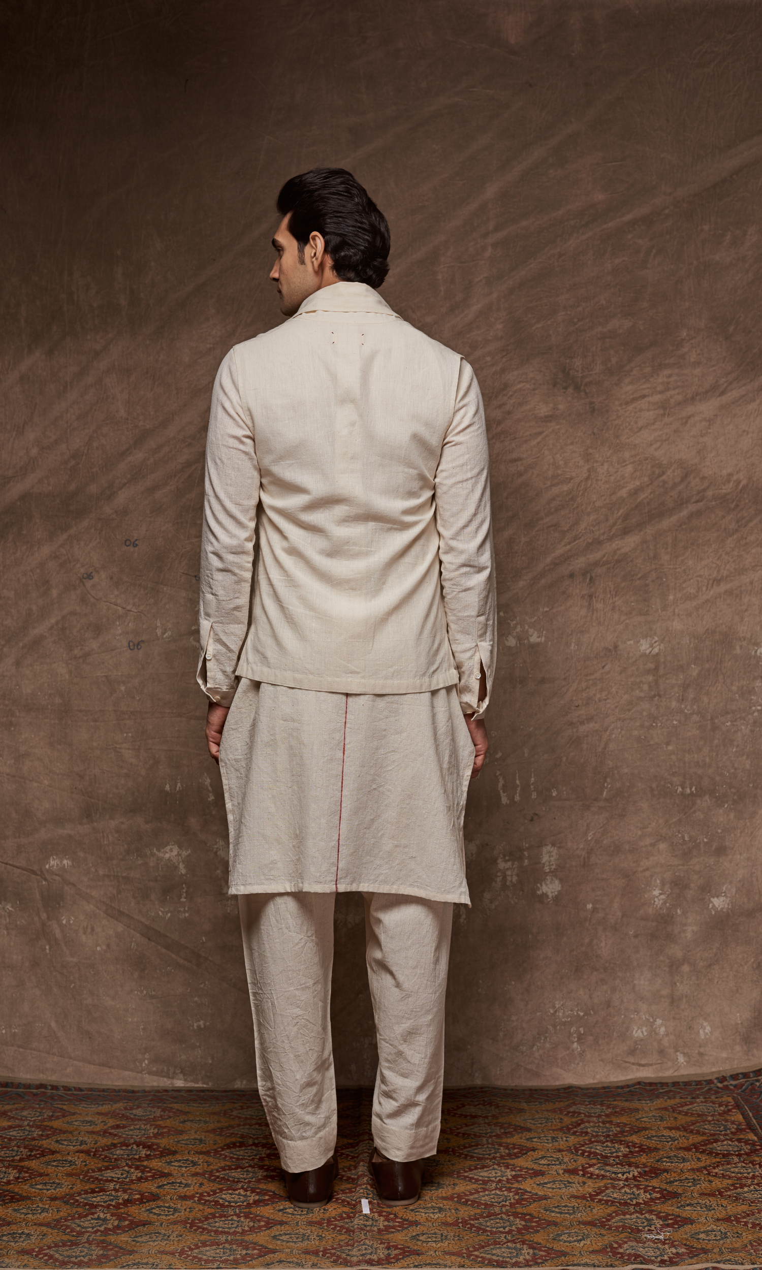Off white cape paired with tonal kurta and indie pants