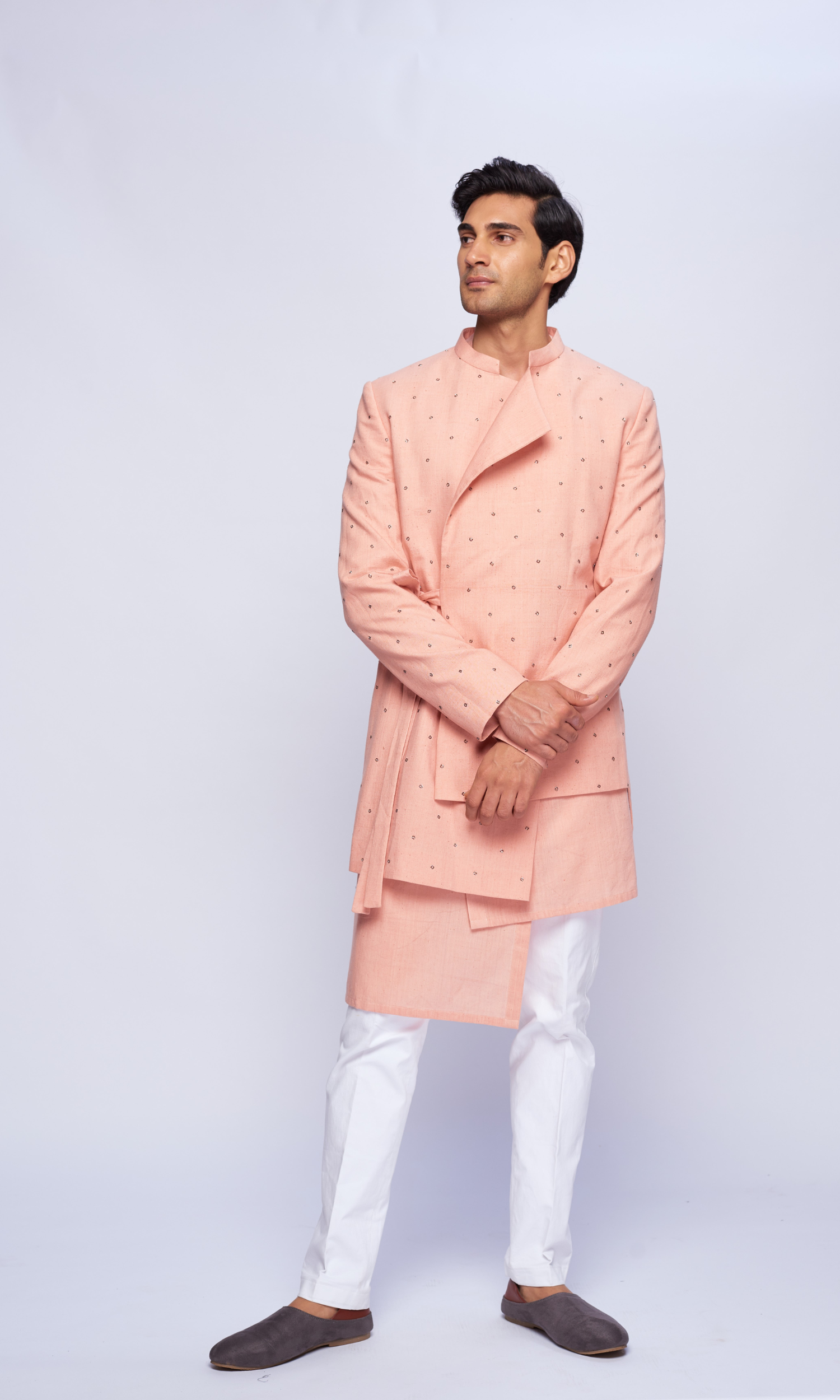 Dusky pink asymmetric all over motifs bandhgala  paired with tonal asymmetric kurta and fitted pants